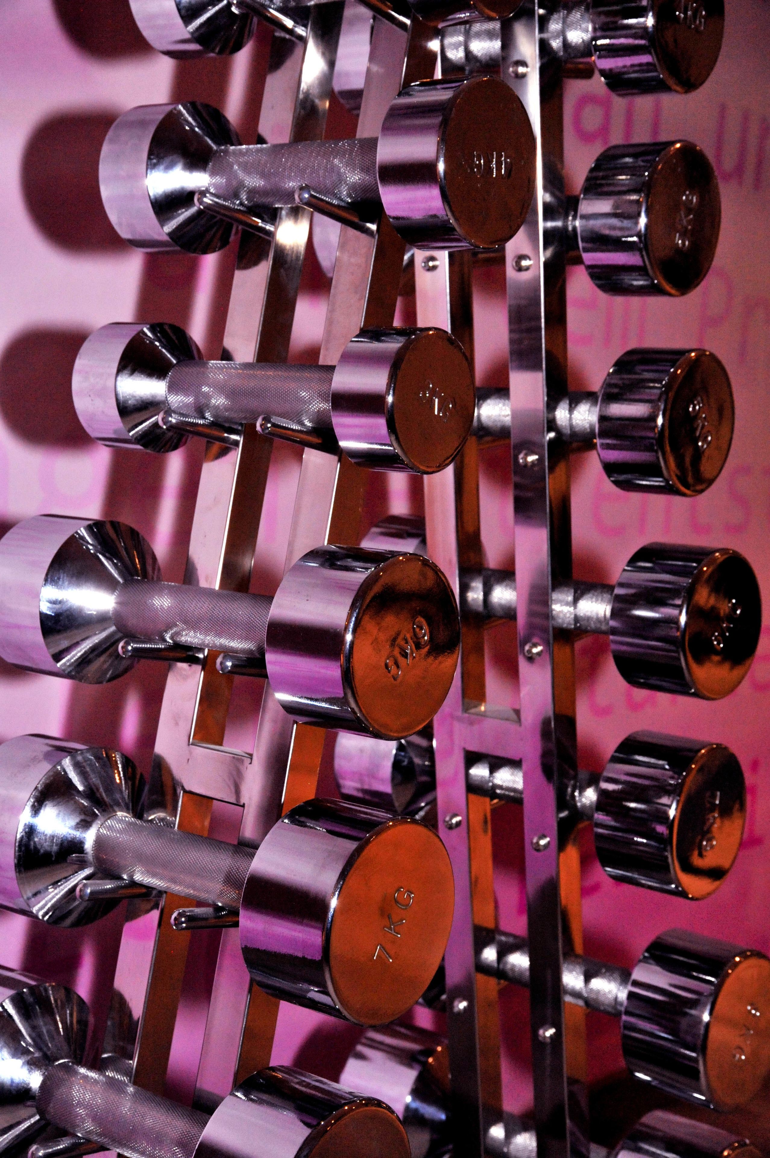 A rack of dumbbells with weights labeled in kilograms.