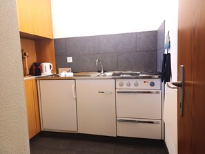A compact kitchen with a stove, oven, and sink.