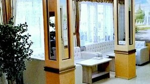 A hotel lobby with a sofa, a coffee table, and a potted plant. - Home Hotel Astana (Astana)