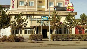 A hotel named 'KONAK ZI' with a 'BINGO BOOM' sign, a 'HOME HOTEL' sign, and a 'ONE HOME' sign. - Home Hotel Astana (Astana)
