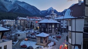 Un paese con edifici, una piccola edicola e una montagna sullo sfondo.