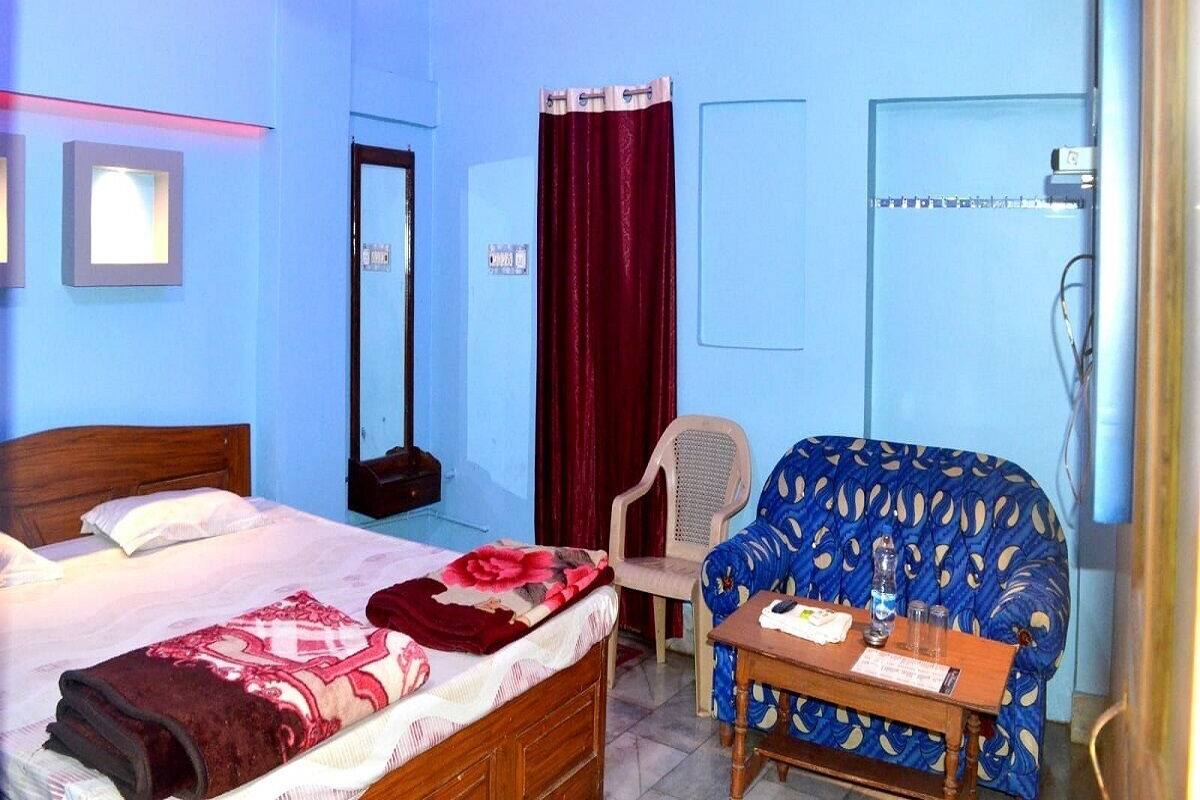 A hotel room with a bed, a chair, a table, and a desk.