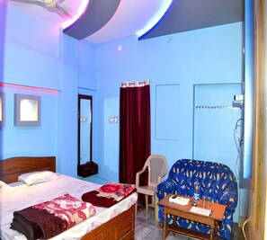 A hotel room with a bed, a chair, a table, and a desk. - Hotel Royal Residency (Pakur)