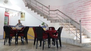 A restaurant with a staircase and a Coca-Cola refrigerator. - Hotel Royal Residency (Pakur)