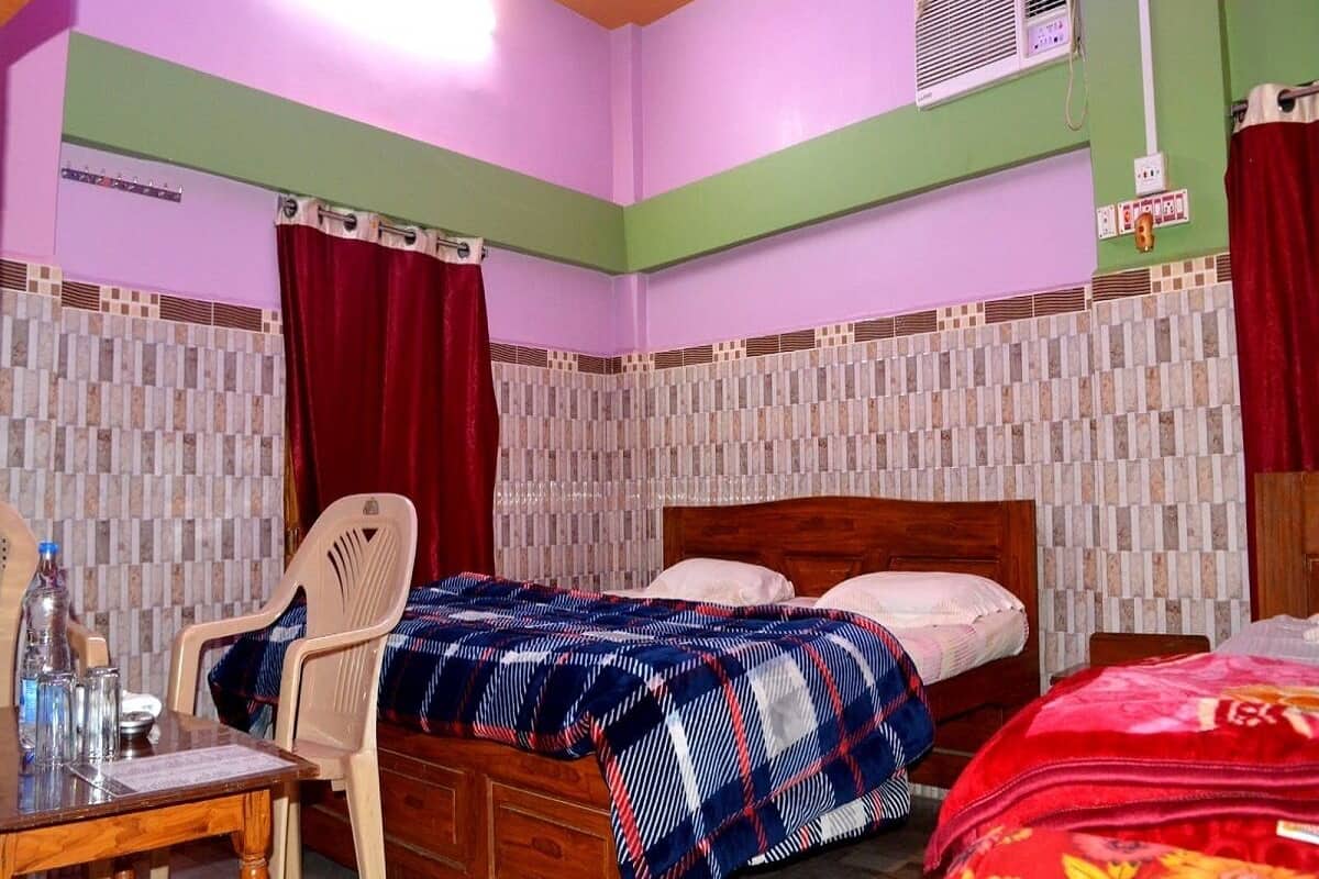 A bedroom with a wooden bed, a desk with a chair, and a red curtain.