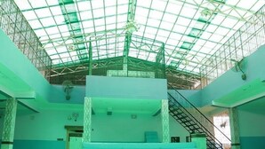 A spacious atrium with a high ceiling, a staircase, and a central seating area. - Hotel Royal Residency (Pakur)