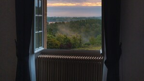 Ein Zimmer mit einem großen Fenster, einem Heizkörper und zwei Stühlen.