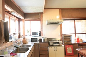 A kitchen with a microwave, toaster, sink, and a refrigerator.