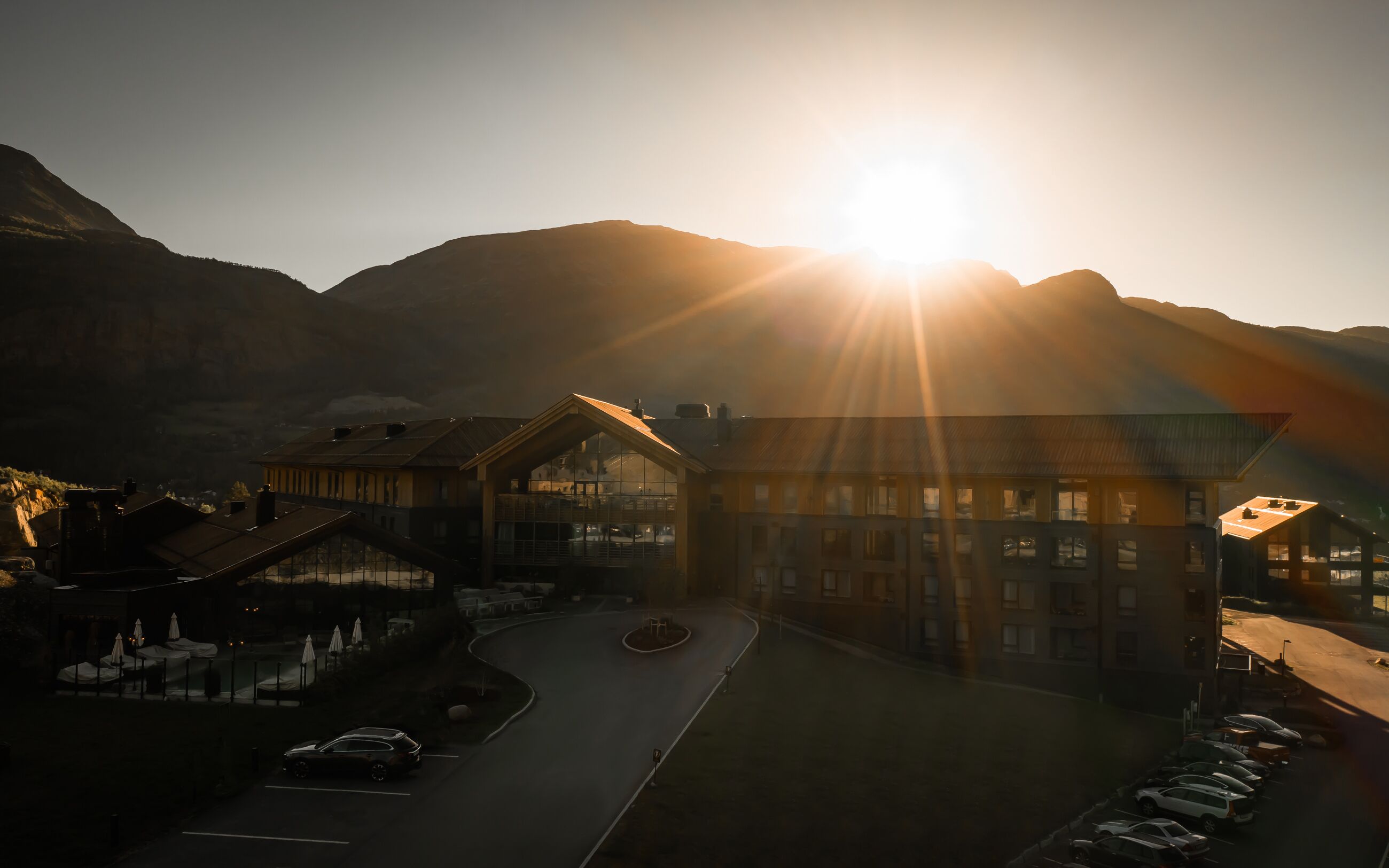 A hotel with a central courtyard, surrounded by mountain views, featuring a mix of traditional and modern architecture.