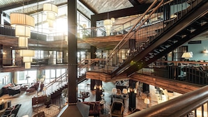 A spacious, multi-level interior with wooden beams, a central staircase, and multiple seating areas. - Fyri Resort Hemsedal (Hemsedal)