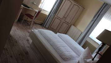 A bedroom with a single bed, a desk, and a chair.