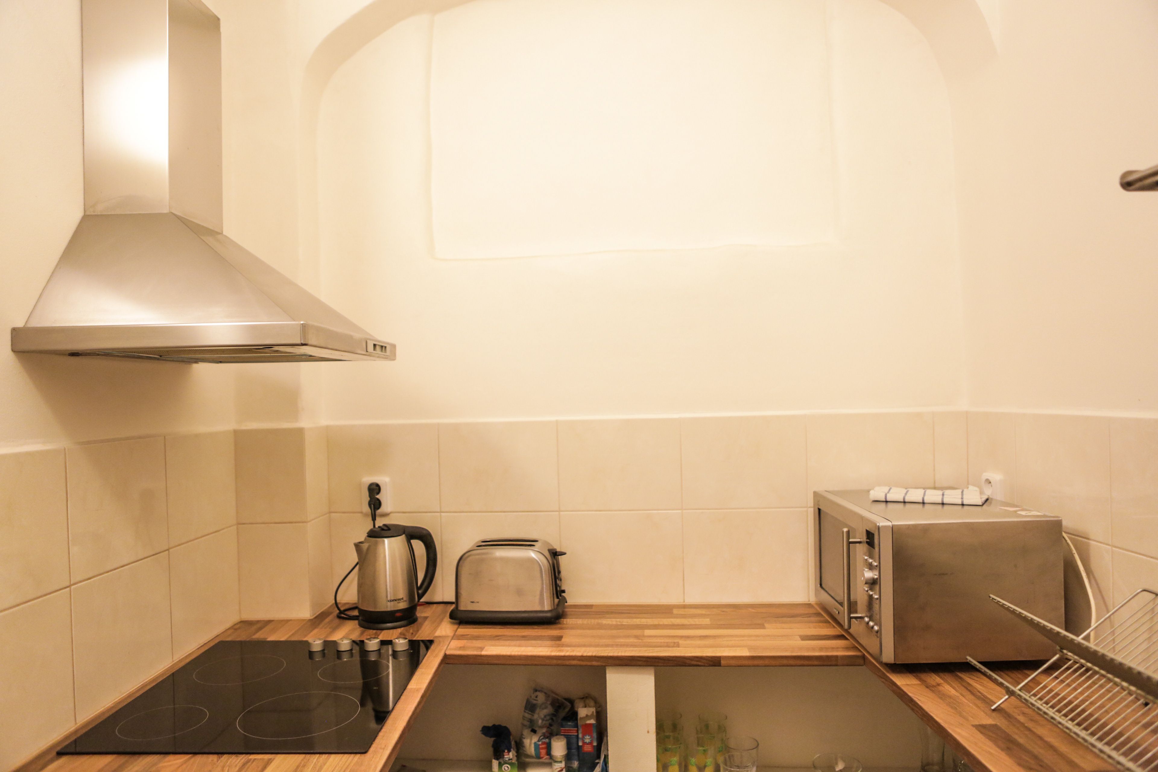 Een keuken met een fornuis, broodrooster, waterkoker en magnetron.