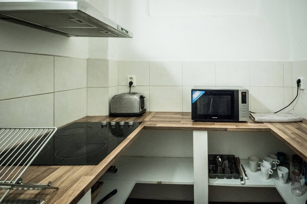 A kitchen with a microwave, toaster, and a wooden countertop.