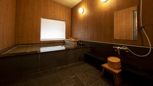Un baño moderno con paneles de madera, un espejo grande, un lavamanos y un inodoro.