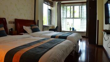Een hotelkamer met twee bedden, een raam met gordijnen, een stoel en een televisie.