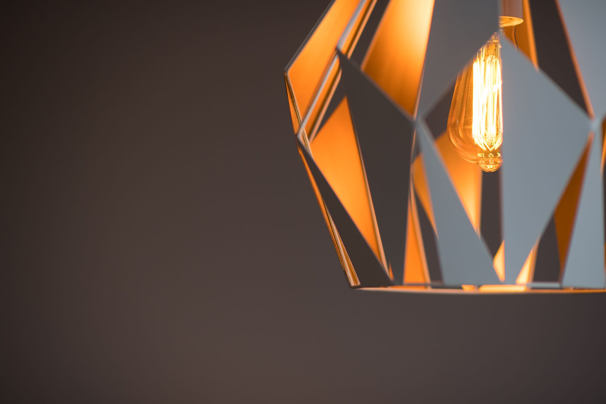 A geometric pendant light fixture with a visible filament bulb.
