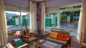 A cozy living room with a sofa, chairs, a coffee table, and a guitar. - Camping Os Fieitás (O Grove)