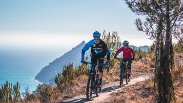 Deux cyclistes sur un chemin de terre, avec une vue sur la côte.