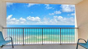 Een balkon met uitzicht op de oceaan en het strand.