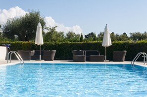 Een seizoensgebonden buitenzwembad en parasols bij het zwembad