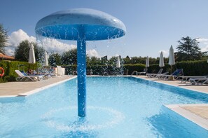 Een seizoensgebonden buitenzwembad en parasols bij het zwembad