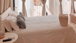 Une chambre d’hôtel avec un grand lit, une petite table avec une lampe et une vue sur l’extérieur.