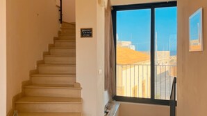 Un escalier menant à un balcon d’où l’on a une vue dégagée sur le paysage urbain.