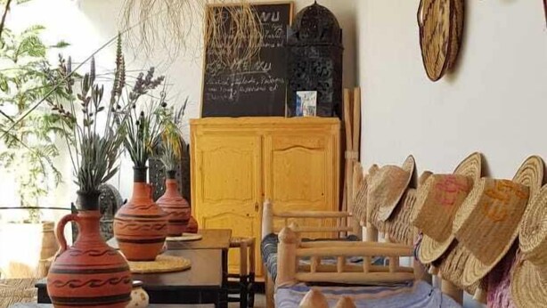 A cozy room with a woven ceiling, wooden furniture, and traditional decor. - Riad Art House (El Jadida)