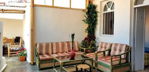 A cozy outdoor seating area with wicker furniture and potted plants.