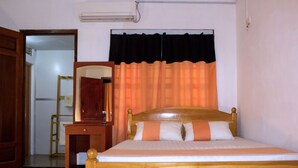 A wooden bed with a headboard, a bedside table, and a mirror. - D'Villa Guest House (Jaffna)