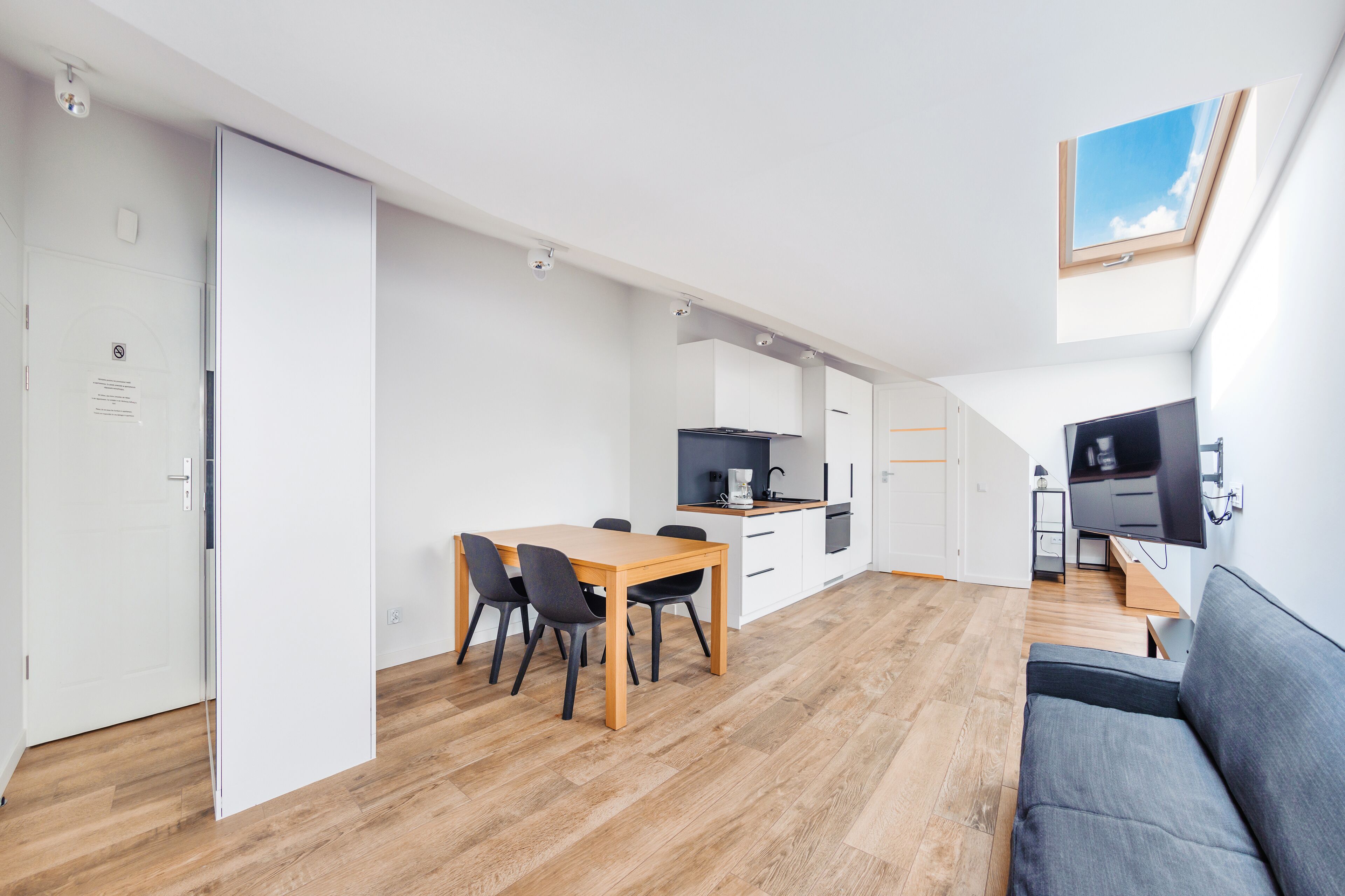 Una cocina moderna con comedor, sofá y televisor.
