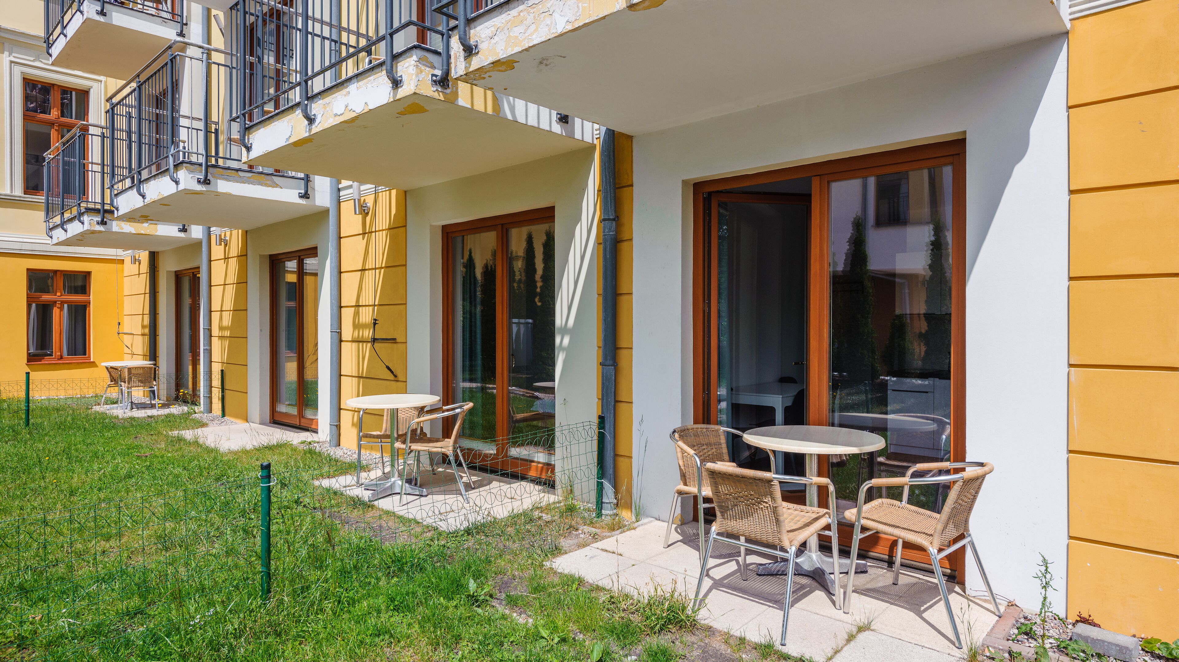 Un bâtiment jaune doté d’une terrasse et d’un balcon.