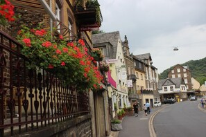 A traditional European street with a massage parlor, a terrace, and a variety of shops.