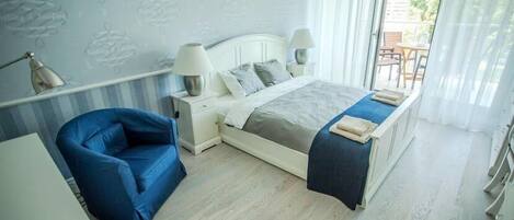 Un dormitorio con cama, lámparas de noche, una silla y un escritorio.