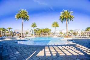 A resort pool area with palm trees, lounge chairs, and a clear blue sky. - 3BR Townhome w/ 6-Seater Golf Cart & Bikes ~ Serenity Shores at Prominence North (Inlet Beach)