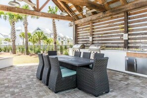 An outdoor patio with a built-in grill and seating area.