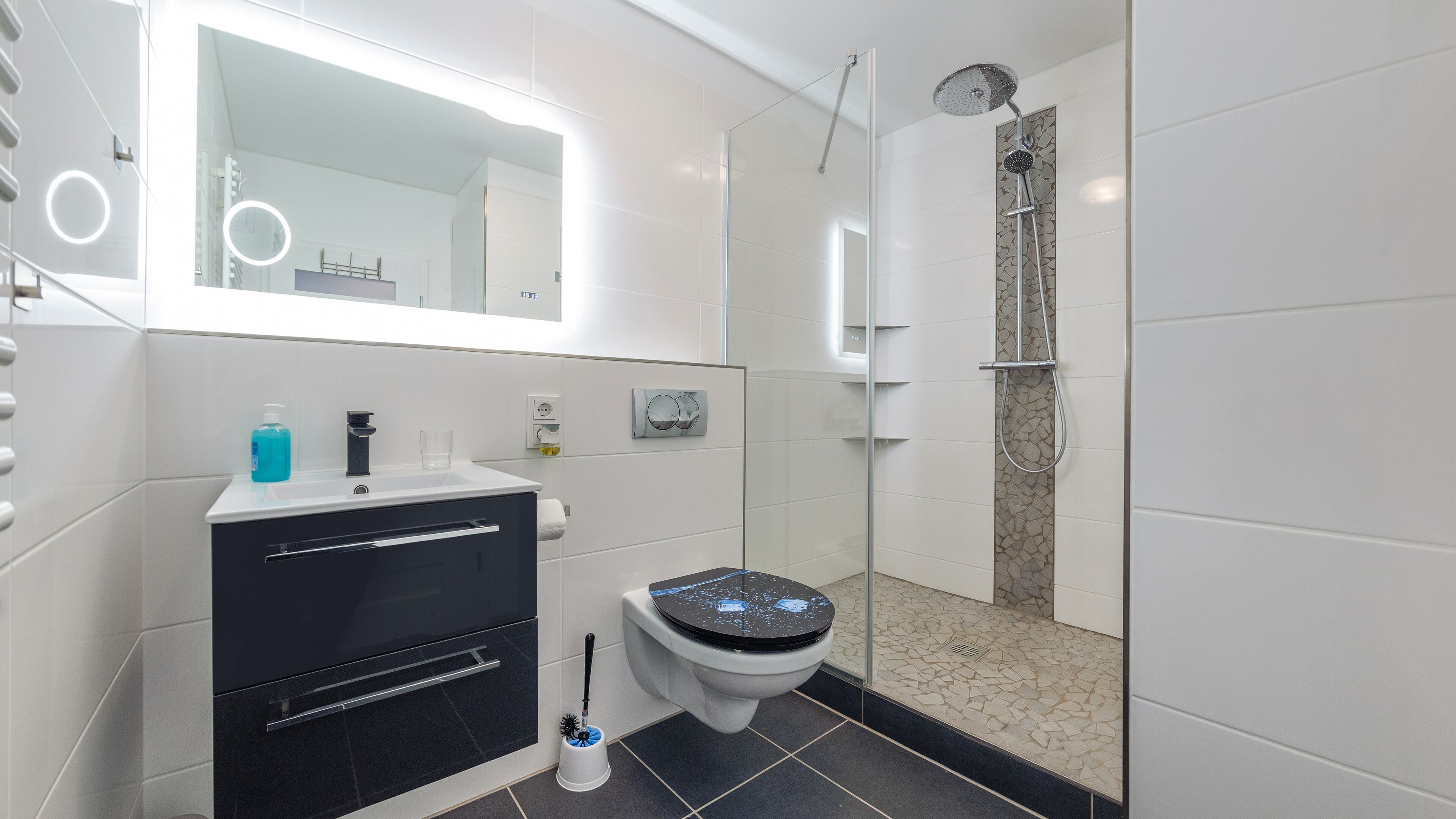 Un bagno moderno con WC, lavandino e doccia.