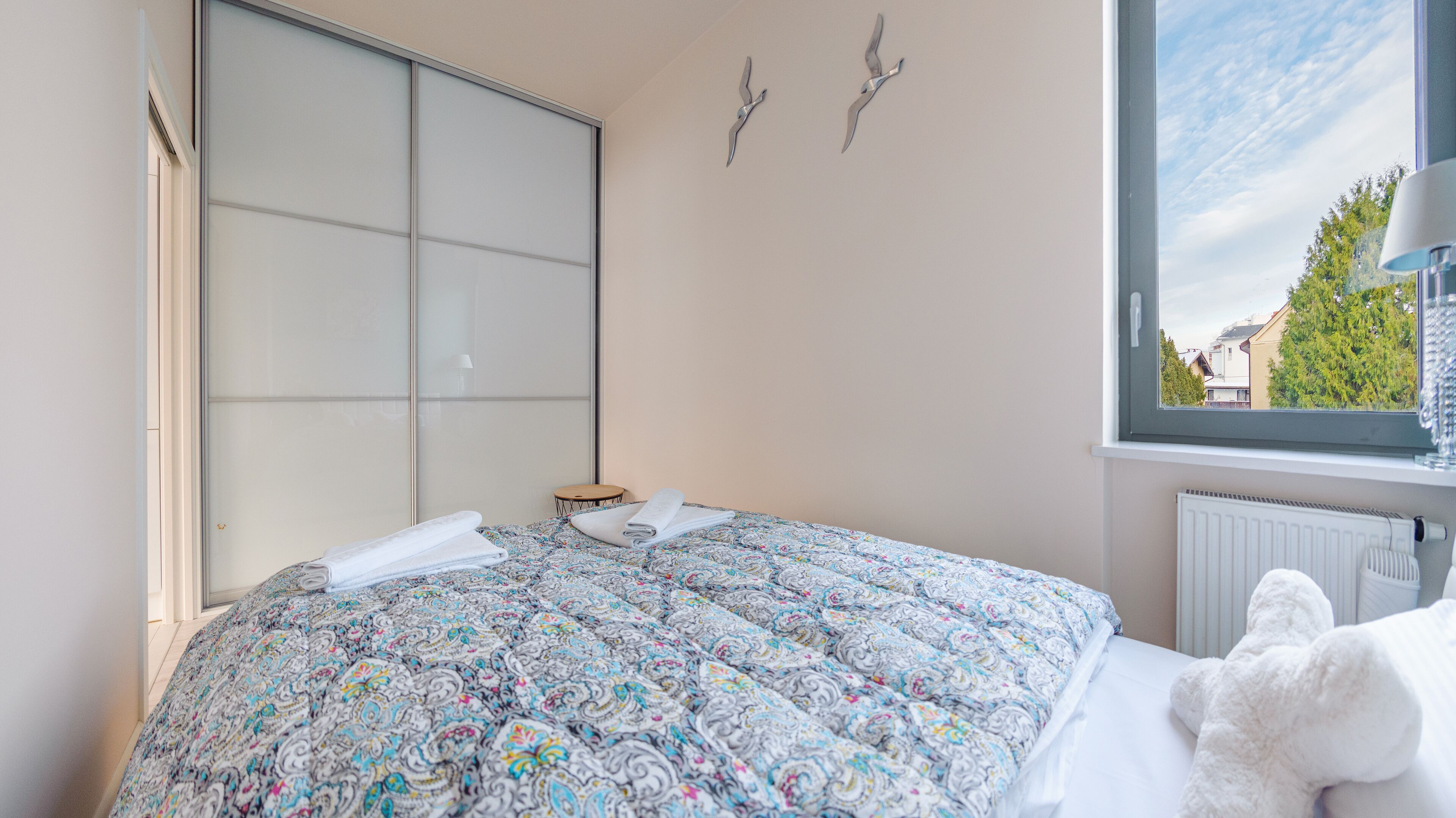 A bedroom with a bed, a window, and a radiator.