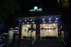 The West Yard Hotel entrance with a glass facade, a staircase leading up to the lobby, and a sign above the entrance. - West Yard Hotels (New Delhi)
