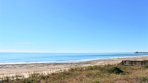 A beach with a wooden boardwalk, sandy beach, and ocean. - Oceanfront 4BR with Panoramic Views & Beach Access (Emerald Isle)
