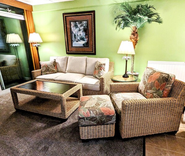 A living room with a sofa, two armchairs, a coffee table, and a lamp.