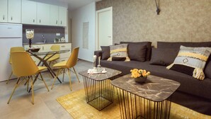 A compact living space with a dining area, a sofa set, and a kitchen.