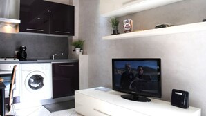 Een moderne keuken met inbouwapparatuur, een flatscreen televisie en een witte console.