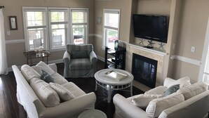 Un salon avec une cheminée, un téléviseur et un canapé.