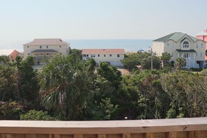Uma área residencial costeira com casas, uma praia e vegetação densa.