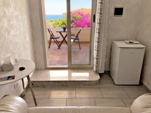 ห้องจูเนียร์สวีท, เตียงควีนไซส์ 1 เตียง, วิวทะเล | บริเวณนั่งเล่น | ทีวีจอแบน