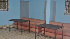 A room with a patterned floor, a sofa, and two tables.