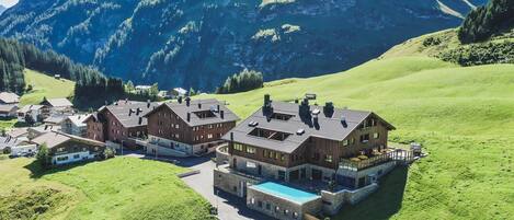 A mountain lodge with multiple buildings, a swimming pool, and a boat dock.