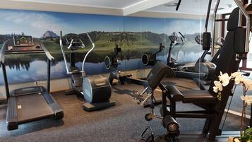 A home gym with cardio equipment, a stationary bike, and a weight machine.