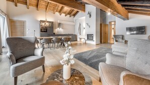 A spacious living area with a high ceiling, wooden beams, and modern furniture. - AlpenParks Hotel & Apartment Arlberg Warth (Warth)